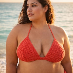 Peut inclure: Haut de bikini en crochet fait à la main, de couleur corail. Le haut triangulaire est doté d'un tour de cou et d'une texture côtelée. L'image est prise en extérieur avec un arrière-plan flou de l'océan.
