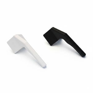 May include: Two window handles, one in matte white and one in matte black, each featuring a rectangular base and an angled lever arm. The handles are positioned side by side, showcasing their identical geometric design and smooth finish.
