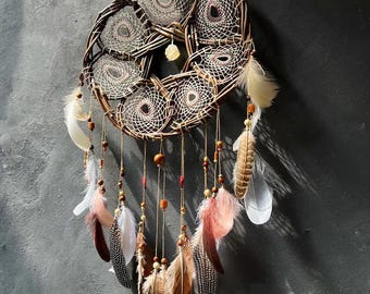 Atrapasueños hecho a mano con vides, plumas y piedras de cristal para decoración de pared.