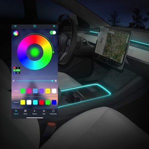 May include: A smartphone app interface with a color wheel and slider for adjusting the color of LED lights. The app also has buttons for style, music, mic, and schedule. The image shows a car interior with LED lights illuminating the center console.