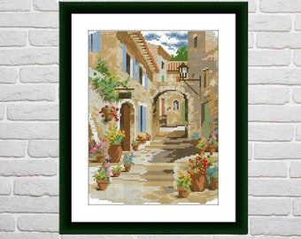 May include: A painting depicting a narrow, cobbled street in a European village. The street is lined with buildings featuring terracotta roofs and colourful flower boxes. The buildings are painted in shades of yellow, brown, and white. The street is empty, but there are flowers in pots on the steps leading up to the buildings.
