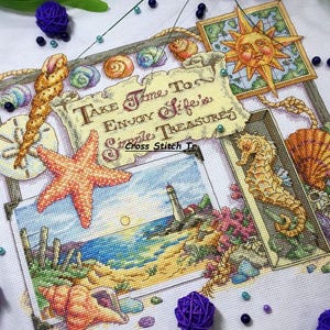 May include: A cross-stitch artwork featuring a coastal theme. The design includes a starfish, seashells, a lighthouse, and a seahorse. The text reads "Take Time To Enjoy Life's Simple Treasures". The color palette includes shades of blue, orange, and beige.