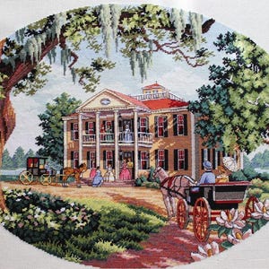 May include: A cross-stitch embroidery depicting a two-story antebellum mansion with a red roof, white columns, and a balcony. The scene includes horse-drawn carriages, figures in period clothing, large oak trees with Spanish moss, and white flowers.