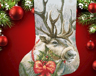 May include: A white reindeer with large antlers is peeking out of a Christmas stocking with a red bow and green holly. The stocking is decorated with a snowy background and the name "Alla" is written at the top.