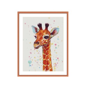 Op de afbeelding: Een close-up van een babygiraffe met een lichtbruin en oranje patroon op zijn vacht. De giraffe heeft een lichtbruine neus en grote, donkere ogen. De achtergrond is lichtbeige met kleurrijke verfspatten.