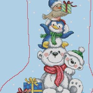 Peut inclure: Une broderie au point de croix d'une chaussette de Noël sur fond bleu clair. La chaussette présente une pile de personnages festifs : un ours polaire, un pingouin et un oiseau, tous portant des chapeaux et des écharpes d'hiver. Deux cadeaux emballés sont en bas.