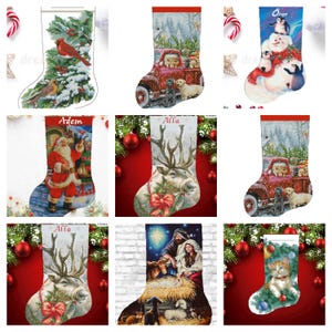 May include: A selection of Christmas stockings with diverse festive designs. The stockings showcase images of a cardinal, a red truck with dogs, Santa Claus, reindeer, penguins, and a nativity scene. Each stocking has a red cuff.