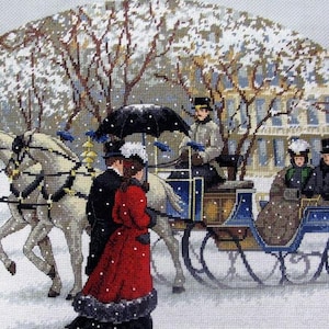 May include: Cross-stitch embroidery depicting a winter scene with a horse-drawn carriage. The carriage is blue and gold, with passengers in period clothing. Snow falls on the trees and buildings in the background. The horses are white.