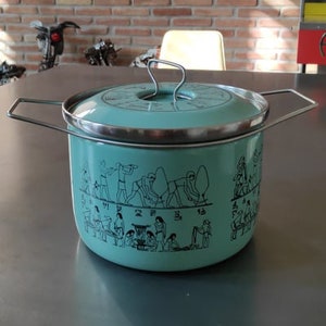 May include: A teal blue enamel pot with a silver lid and handles. The pot features a black and white design of people in a line, possibly depicting an ancient Egyptian scene.