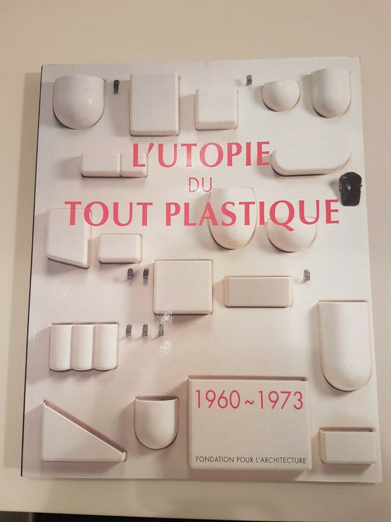 May include: A white book cover with the title "L'Utopie du Tout Plastique 1960~1973" and the text "Fondation pour l'Architecture". The cover features a design of various white plastic shapes.