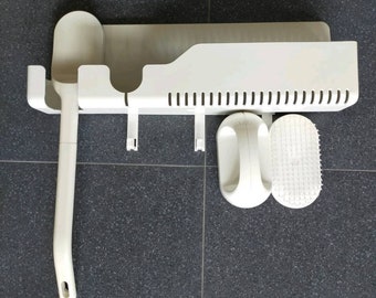 May include: White plastic bathroom organizer with a long-handled brush, a sponge, and a scrub brush. The organizer has a shelf and hooks for hanging items.