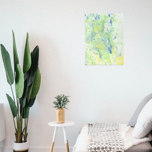 Pode incluir: Pintura abstrata com cores azuis, verdes e amarelas em espiral sobre um fundo branco. A pintura est&aacute; pendurada em uma parede branca em uma sala de estar.