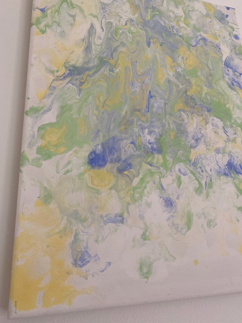Pode incluir: Pintura abstrata com padr&otilde;es em espiral em tons de azul, verde e amarelo sobre uma tela branca.