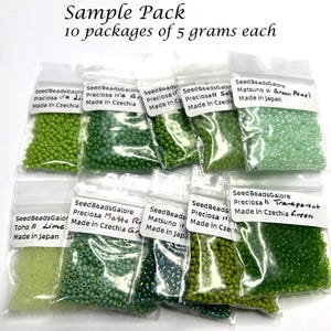 Puede incluir: Un paquete de muestra con 10 bolsas de plástico transparente resellables, cada una llena con 5 gramos de pequeñas cuentas de semillas verdes. Las etiquetas de las bolsas incluyen texto como SeedBeadsGalore, Preciosa, Toho, Matsuno.