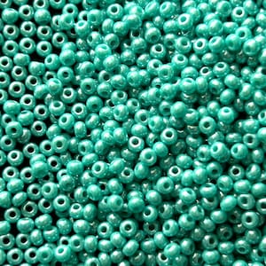 Peut inclure: Une image en gros plan d'une grande quantité de perles de rocaille turquoise. Les perles sont petites et rondes, avec une finition lisse et brillante.