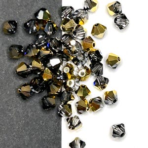May include: A mix of gold and black crystal beads. The beads are faceted and have a shiny finish.