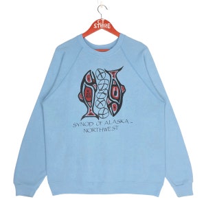 May include: Light blue sweatshirt with a graphic of two stylised fish and the text "Synod of Alaska - Northwest".