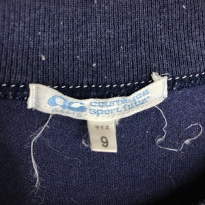 May include: A white tag with blue text that reads "Courreges Sport futur" and "サイズ 9".