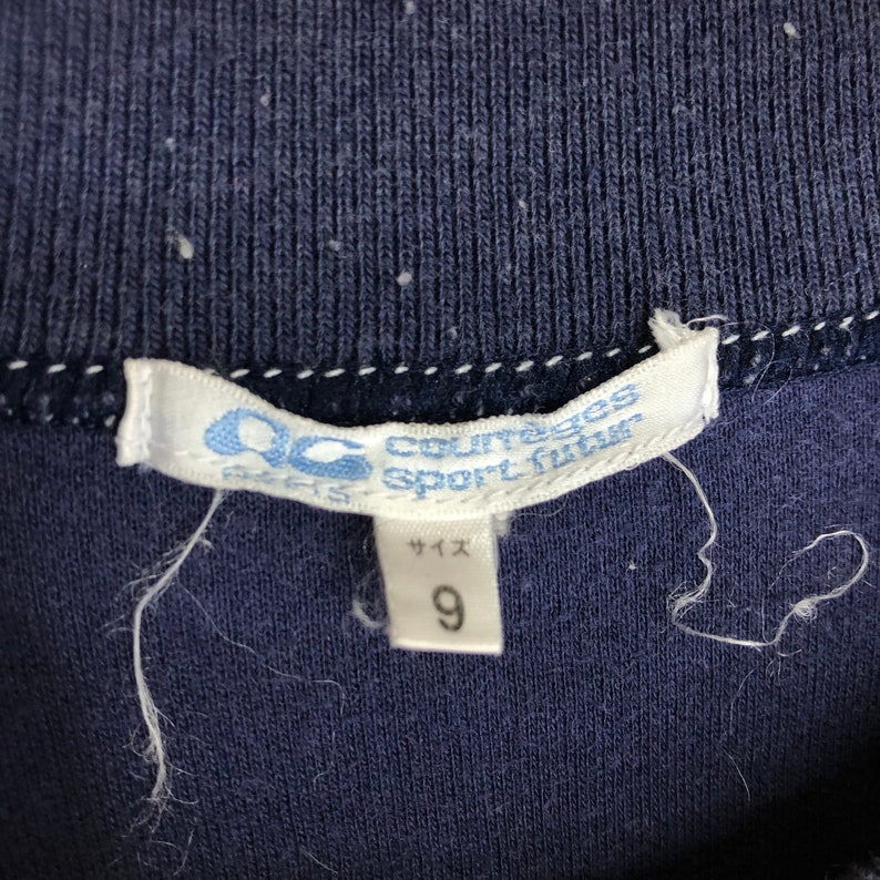 May include: A white tag with blue text that reads "Courreges Sport futur" and "サイズ 9".
