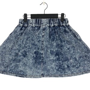 Op de afbeelding: Een blauwe denim rok met een distressed look. De rok heeft een elastische tailleband en een uitlopende silhouet.