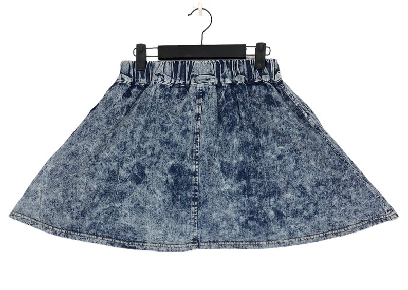 Op de afbeelding: Een blauwe denim rok met een distressed look. De rok heeft een elastische tailleband en een uitlopende silhouet.