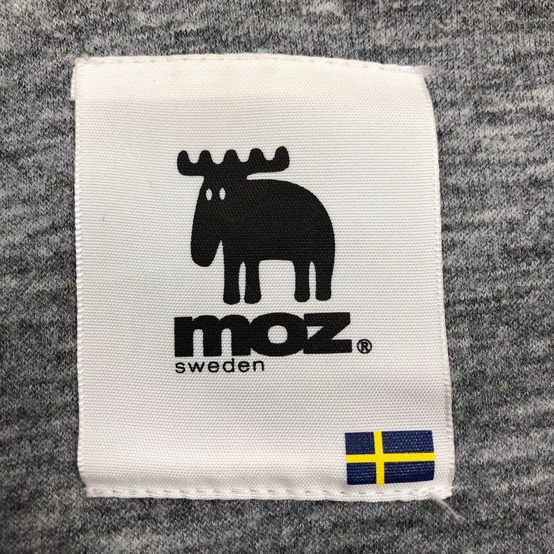 May include: White label with a black moose illustration and the text "moz sweden" with a registered trademark symbol. A small Swedish flag is in the bottom right corner.