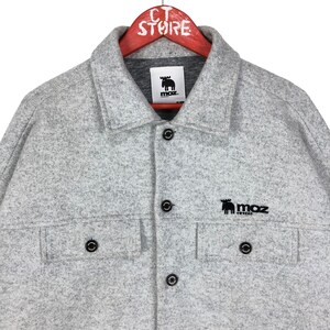 May include: Gray fleece shirt jacket with a black moose logo and the text "moz sweden".