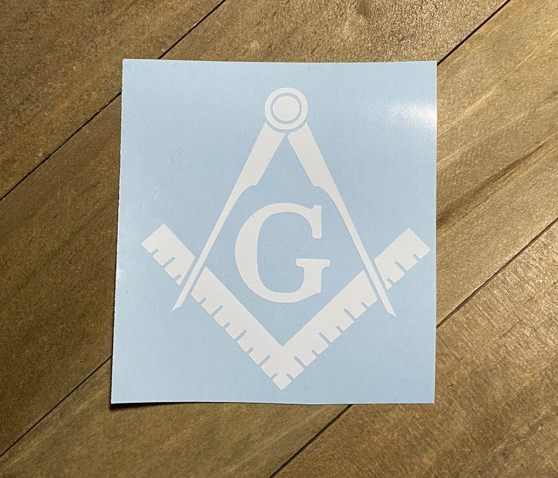 May include: White vinyl decal of a Masonic compass and square with the letter "G" in the center.