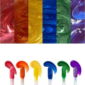 Könnte beinhalten: Eine Sammlung von sechs schimmernden Lipgloss in Regenbogenfarben. Die Farben umfassen Rot, Orange, Gelb, Blau, Grün und Lila. Jeder Gloss wird in einem Farbmuster und in einer Nahaufnahme gezeigt, die die glänzende Textur hervorhebt.