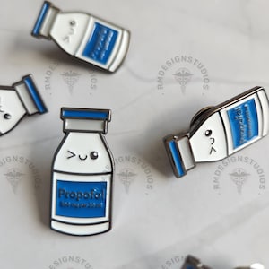 May include: Four enamel pins shaped like bottles with a cartoon face and the word "Propofol" on the label. The pins are silver with blue and white accents.