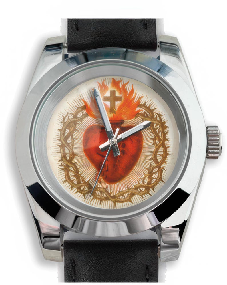 May include: A silver-toned wristwatch with a black leather band. The watch face features a religious design with a red heart, a crown of thorns, a cross, and flames. The watch hands are silver.