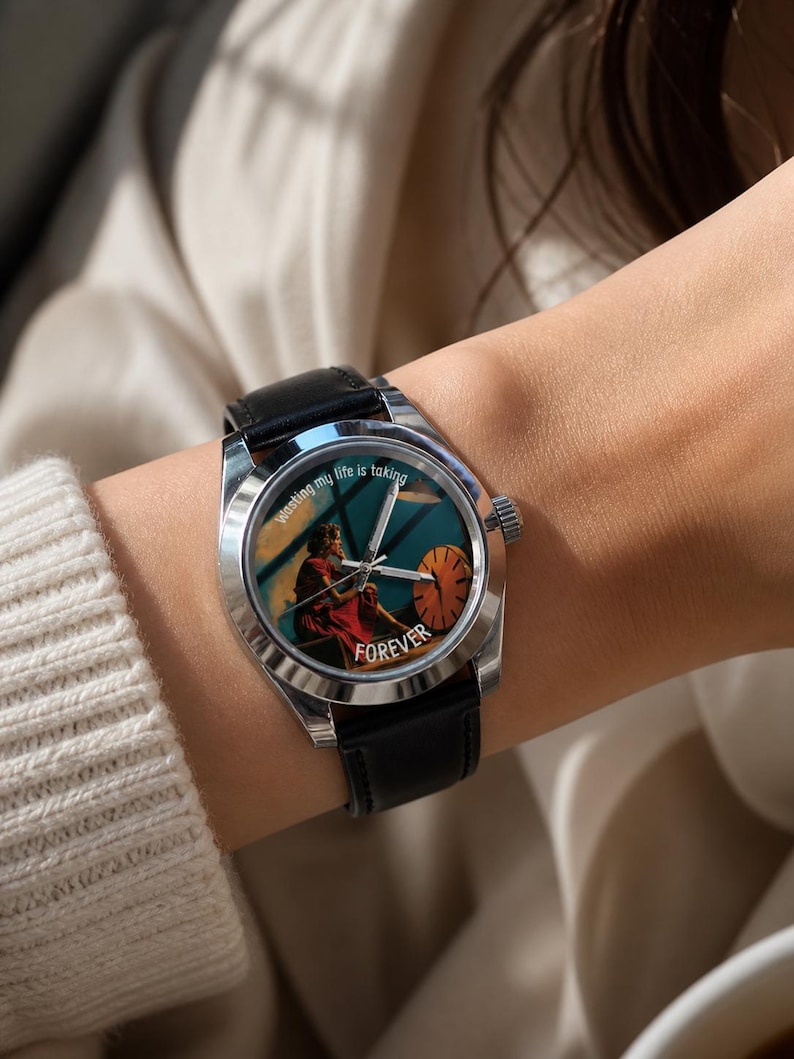 May include: A wristwatch with a black leather strap and a silver case. The watch face displays an illustration of a person in a red dress and the word "FOREVER". The text "Wasting my life is taking" is printed on the watch face.
