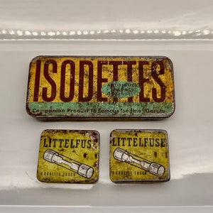 May include: Three vintage boxes with yellow and brown labels. The top box reads "ISODETTES Companion Product to Famous Isodine Gargle". The two smaller boxes read "LITTELFUSE 5 QUALITY FUSES".