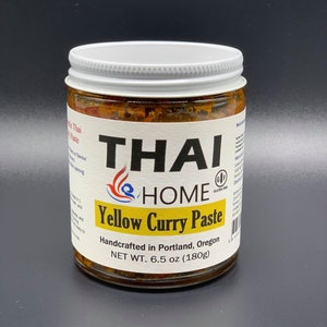 May include: A glass jar of Thai Home Yellow Curry Paste, handcrafted in Portland, Oregon. The jar is labeled with the brand name, product name, and net weight of 6.5 ounces (180 grams).