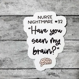 Pu&ograve; includere: Adesivo bianco con testo nero che dice "Nurse Nightmare #32" e "Have you seen my brain?" con un'illustrazione di cervello rosa sotto il testo.
