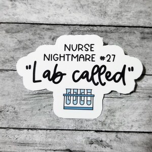 Pu&ograve; includere: Adesivo bianco con testo nero che recita "Nurse Nightmare #27 "Lab called" con un'immagine di un porta provette con cinque provette.
