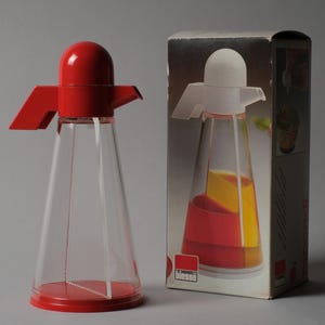 Time Capsule Quality. This third image highlights the exceptional "New Old Stock" status of the Bicondi cruet, shown alongside its original 1980s commercial packaging. Finding these plastic pieces with their retail box intact is significant for collectors, as it preserves the original marketing intent and graphic design of the Biesse brand.