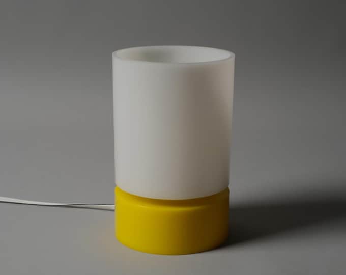 Vintage 1970s Harvey Guzzini table lamp with yellow cylindrical base and opaline diffuser.