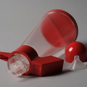 The Interaction Point. This sixth and final image provides a dynamic close-up of the Bicondi's red top assembly, showcasing the pivot mechanism that gives the object its name and unique utility.