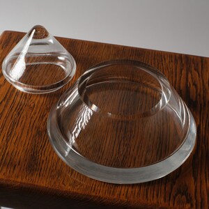 The Disassembled Pyramid. This fifth image reveals the functional core of the bonbonnière. By removing the lid, we see that the base is not just a support, but a shallow, circular bowl. The thickness of the crystal "floor" is substantial, providing the optical depth seen in previous profile shots while ensuring the vessel remains grounded and sturdy.