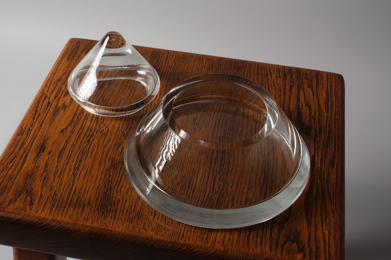 The Disassembled Pyramid. This fifth image reveals the functional core of the bonbonnière. By removing the lid, we see that the base is not just a support, but a shallow, circular bowl. The thickness of the crystal "floor" is substantial, providing the optical depth seen in previous profile shots while ensuring the vessel remains grounded and sturdy.