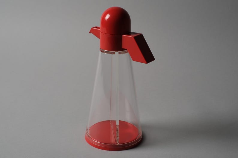 Angular Utility. This fourth image focuses on the rear of the Bicondi cruet, detailing the geometric handle that defines the unit's ergonomics. The handle's sharp, blocky aesthetic is a clear nod to the Memphis Group influence that permeated Italian kitchenware in the mid-1980s.