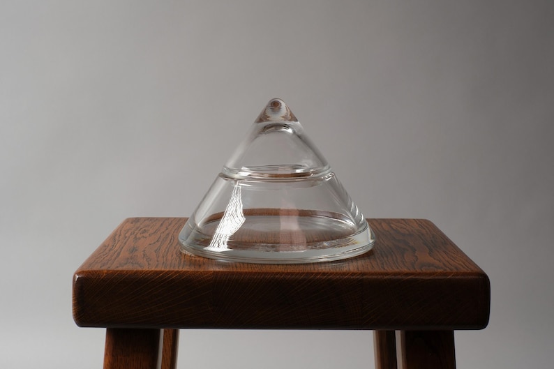 The Balanced Profile. This third image highlights the object's clean, architectural symmetry. From this level perspective, the "glass-on-glass" connection becomes the central design element. The weight of the solid crystal lid provides enough downward pressure to keep it securely in place without the need for a rubber gasket or threaded rim, maintaining the purity of the Postmodern aesthetic.