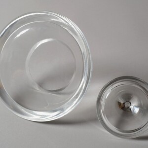The Underside Foundation. This seventh and final image reveals the base of both components from a high angle. The underside of the vessel is characterized by a wide, flat, polished ring that provides maximum surface contact, ensuring the heavy crystal pyramid remains stable on any flat surface. This perspective also highlights the annular geometry of the piece, with concentric circles formed by the varying thicknesses of the crystal walls.