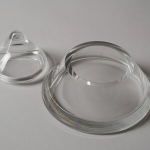 Structural Integrity. This sixth image displays the lid and base side-by-side on a neutral backdrop, allowing us to appreciate the thickness of the glass walls. In 1980s crystal production, such substantial wall thickness was a sign of luxury, providing the "heft" expected of high-end decorative objects.