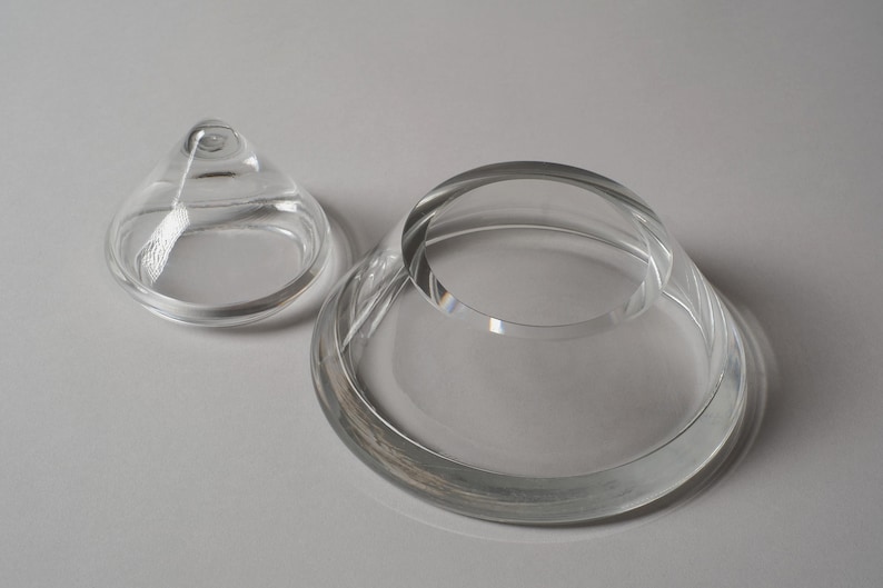 Structural Integrity. This sixth image displays the lid and base side-by-side on a neutral backdrop, allowing us to appreciate the thickness of the glass walls. In 1980s crystal production, such substantial wall thickness was a sign of luxury, providing the "heft" expected of high-end decorative objects.