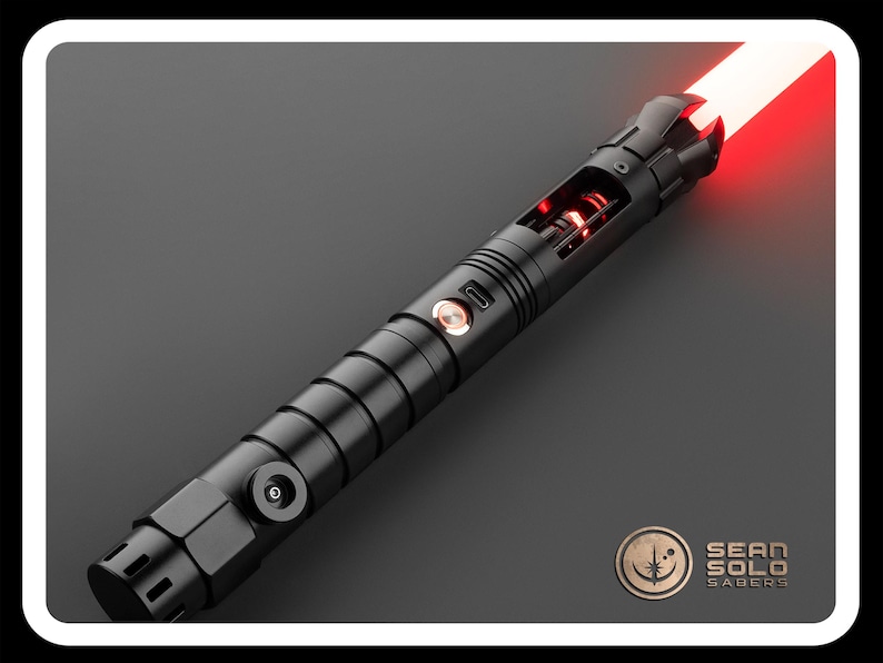 May include: A black lightsaber with a red blade. The lightsaber has a textured grip and a silver button on the side. The blade is lit and extends from the hilt.