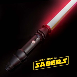 Może przedstawiać: Czarny miecz świetlny z czerwoną klingą. Miecz świetlny ma czarną rękojeść z srebrnym przyciskiem i czarnym emiterem. Klinga jest zapalona i emituje czerwone światło. Miecz świetlny znajduje się na czarnym tle. Logo Sean Solo Sabers znajduje się w prawym dolnym rogu obrazu.