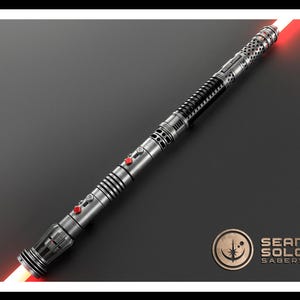 May include: A double-bladed lightsaber with a metallic silver and black hilt featuring intricate perforated detailing, ribbed grip sections, and two prominent red activation buttons. The weapon emits glowing red light from both ends. Sean Solo Sabers logo.