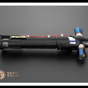 May include: A black lightsaber with a red wire and blue exhaust ports. The lightsaber is made by Sean Solo Sabers.